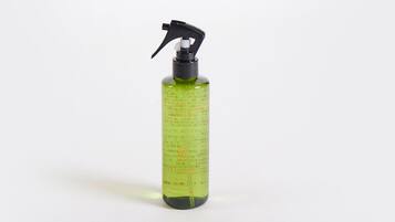 Una bottiglia spray verde con indicazioni di misurazione e testo, probabilmente un prodotto per la pulizia.
