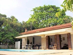 Área comum com Piscina, churrasqueira e sala de estar.