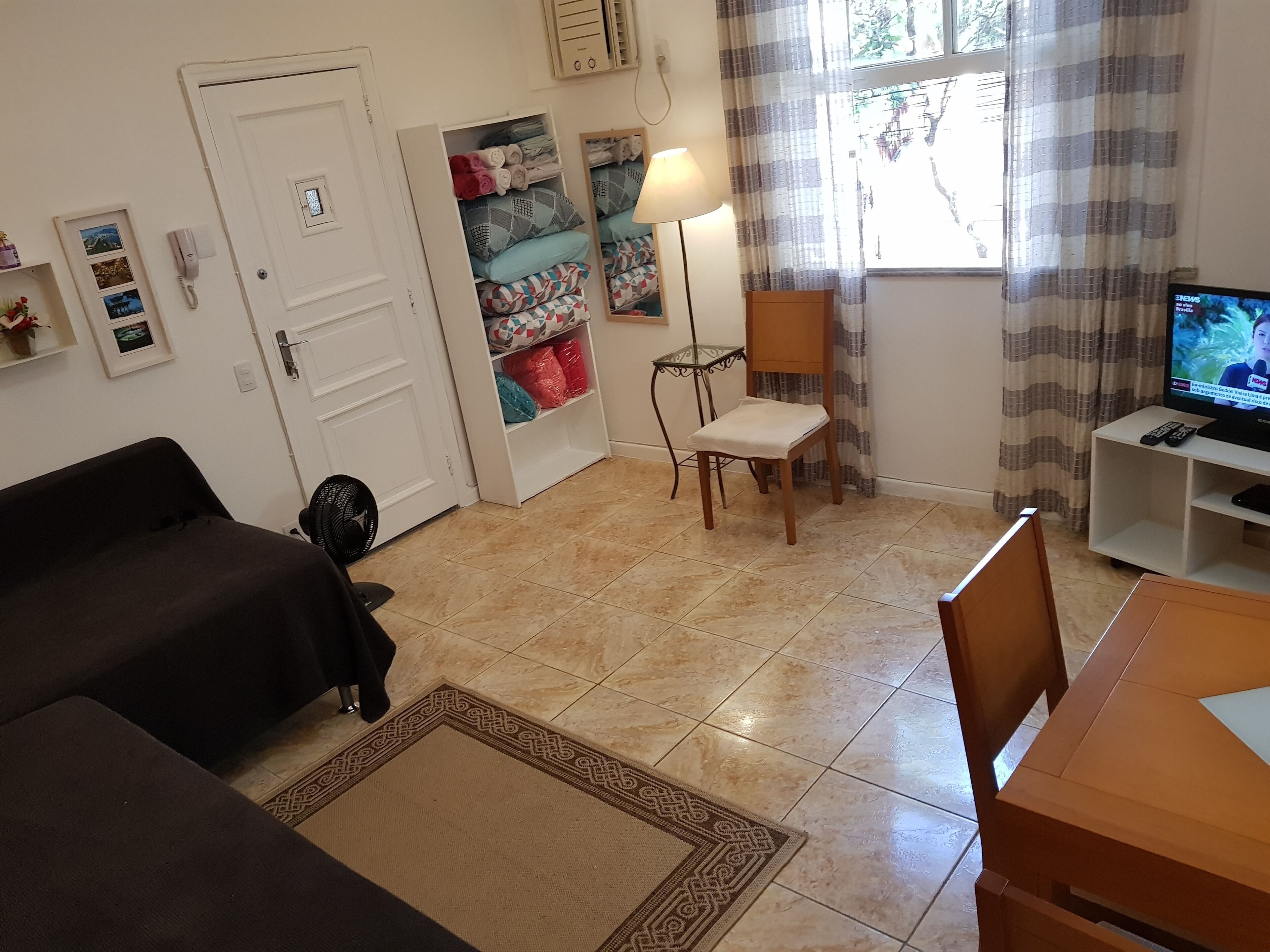 Una sala de estar con un sofá, un sillón, un televisor y una lámpara.