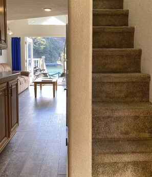 Eine Treppe führt zu einer Außenterrasse mit Blick auf ein Gewässer.