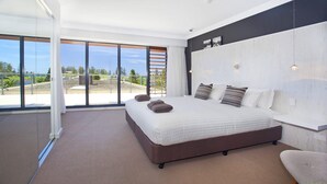Une chambre moderne avec un grand lit, une vue sur l’extérieur et un design minimaliste.