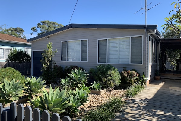 Front of house and board walk leading to the front door under the side deck.