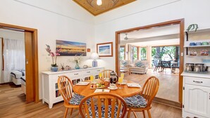 A dining area with a wooden table, chairs, and a view of the outdoor seating area.