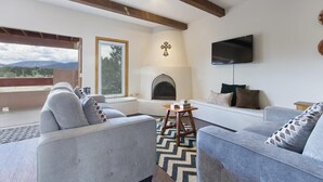 Una sala de estar moderna con chimenea, asientos cómodos y televisor.