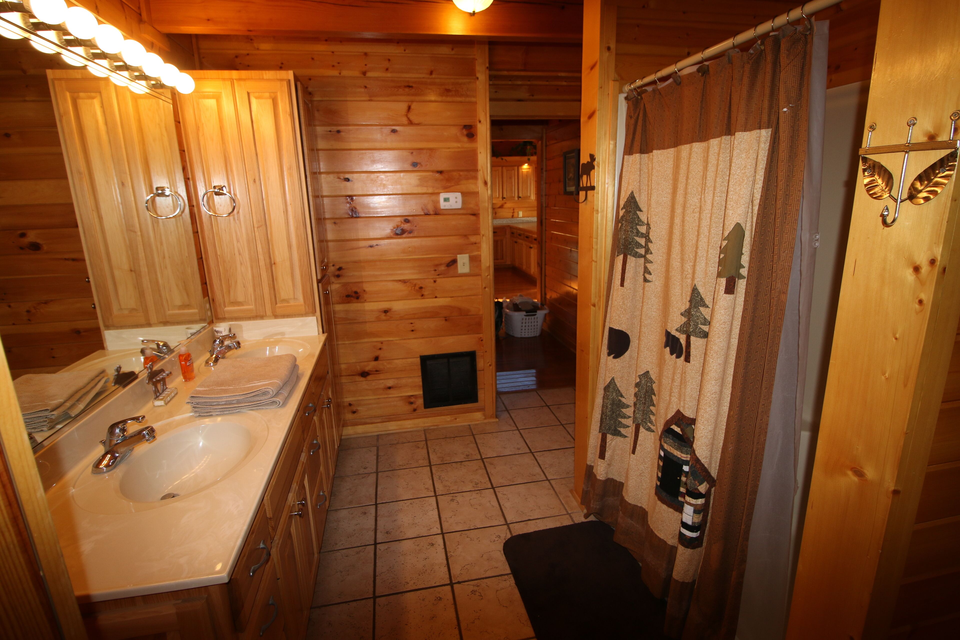 A wooden cabin bathroom with a sink, mirror, and towel rack.