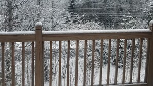 A snowy mountain landscape with a wooden deck and railing in the foreground. - Mount Snow Mountain Views - Spacious and Clean 4 Bedrooms 3 Baths Condo  (West Dover)
