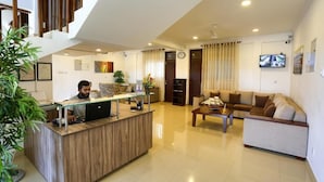 A modern reception area with a wooden reception desk, a sofa, and a coffee table. - Shamaz Galle (Galle)
