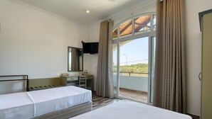 A hotel room with two beds, a desk, a chair, a television, and a balcony with curtains. - Shamaz Galle (Galle)