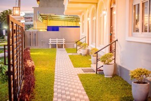 A pathway leading to a building with a white bench and potted plants. - Shamaz Galle (Galle)