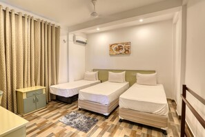 A hotel room with two single beds, a small desk, a cabinet, and a patterned rug. - Shamaz Galle (Galle)