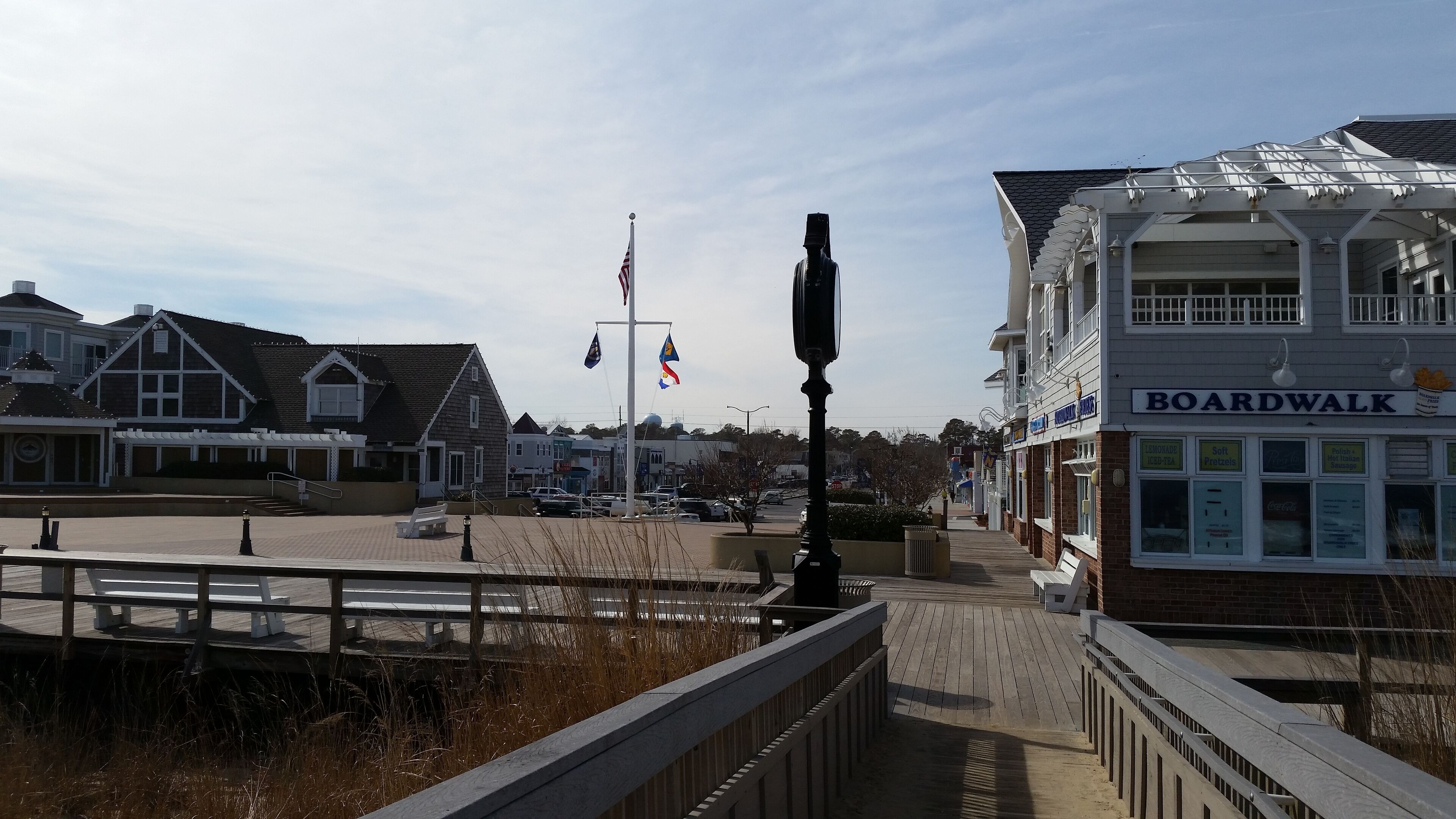En træpromenade med en restaurant ved navn BOARDWALK, komplet med et skilt der viser forskellige retter.