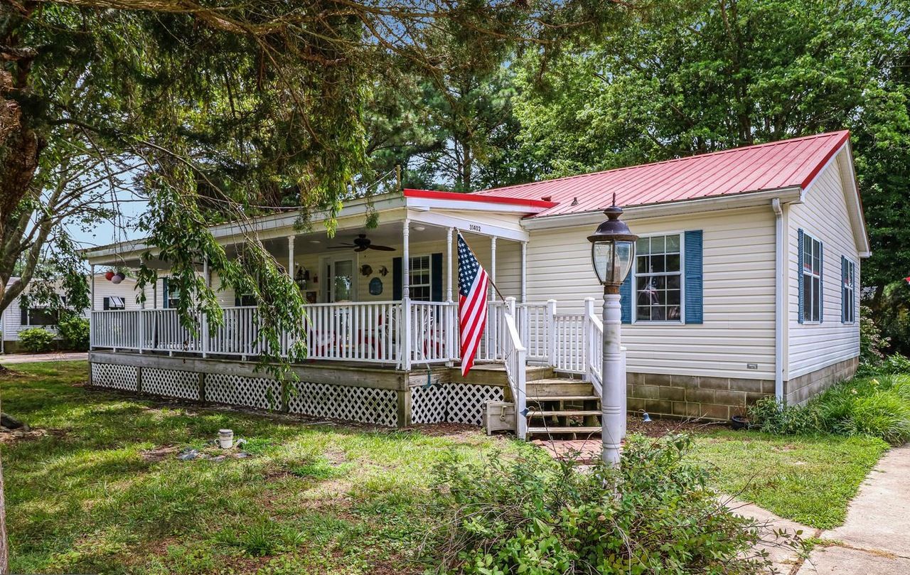 Einbungalow mit rotem Dach, einer Veranda und einer amerikanischen Flagge.