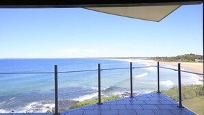 Un balcon donnant sur la mer, avec vue sur l’océan et la plage.