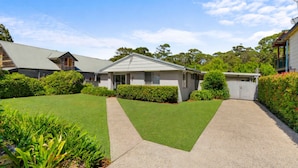 A residential house with a well-maintained lawn, a driveway, and a garage. - Gone Fishing! - ideal for larger families and groups with pets (Culburra Beach)