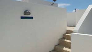 Un bâtiment blanc avec une antenne parabolique et une boîte aux lettres.