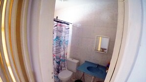 Un bagno con il water, un lavandino e una tenda da doccia.