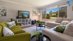 A living room with a TV, sofa, and bookshelf.