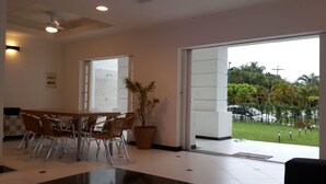 A modern reception area with a large window, a reception desk, and several chairs. - 4 SUITES WITH ARCOND SPLIT, WI-FI, SKY, SOLARIUM POOL. NEAR THE BEACH (Bertioga)