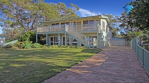 A two-story house with a covered porch and a fenced yard.