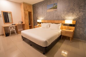 Een hotelkamer met een bed, een bureau, een stoel en een kledingkast.