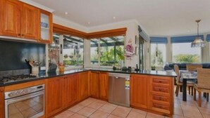 Une cuisine moderne avec des meubles en bois, un four encastré et un lave-vaisselle.