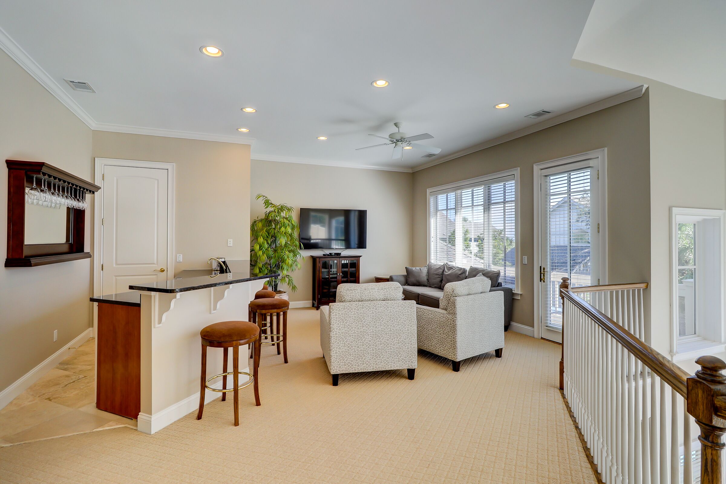 A spacious living area with a kitchen island, seating, and a balcony.