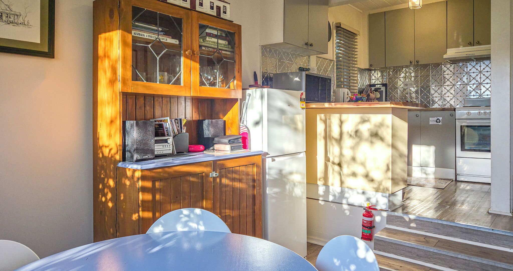 Une cuisine avec des meubles de rangement en bois, un réfrigérateur, un four à micro-ondes et une cuisinière.