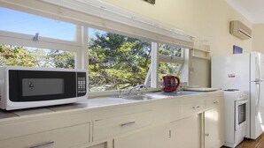 A kitchen with a microwave, kettle, and refrigerator. - Bij's on the Beach – walking distance to beach (Lake Conjola)