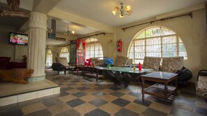 A spacious lobby with a checkered floor, a large wooden coffee table, and comfortable seating. - Heritage Bliss Hotel (Kitui)