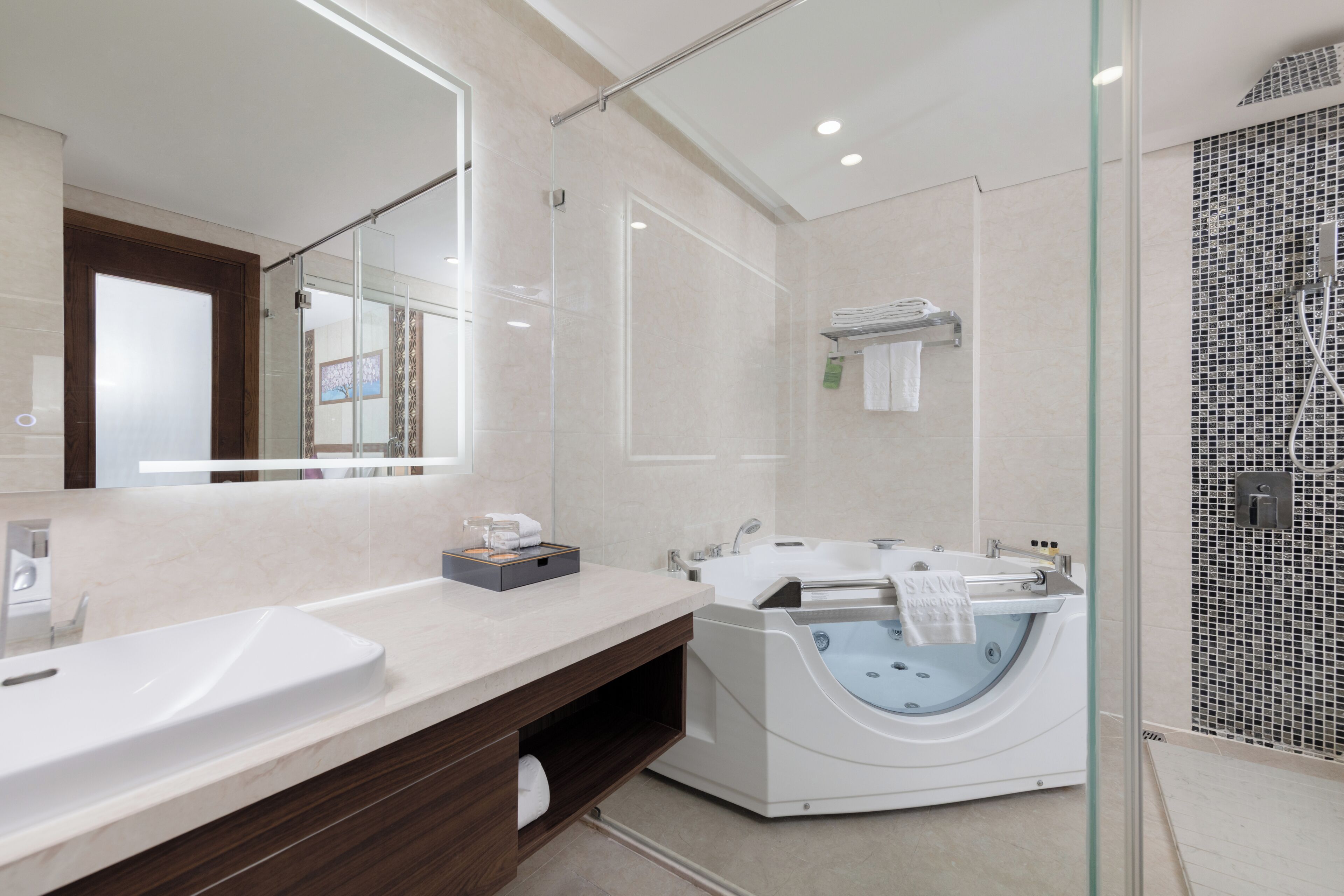 Une salle de bain moderne avec une douche à parois de verre, une baignoire sur pieds et un grand miroir.