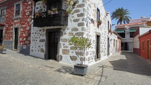 A stone building with a balcony and potted plants. - SPACIOUS HOUSE IN THE FIELD: Ada´s House 2 (Santa Brígida)