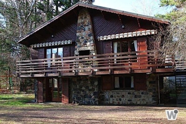 A rustic cabin with a stone foundation, wooden upper structure, and a balcony. - Chalet - MurolHouse with character (Murol)
