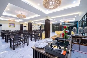 Un'ampia hall d'hotel con soffitto alto, lampadari moderni e una reception centrale.