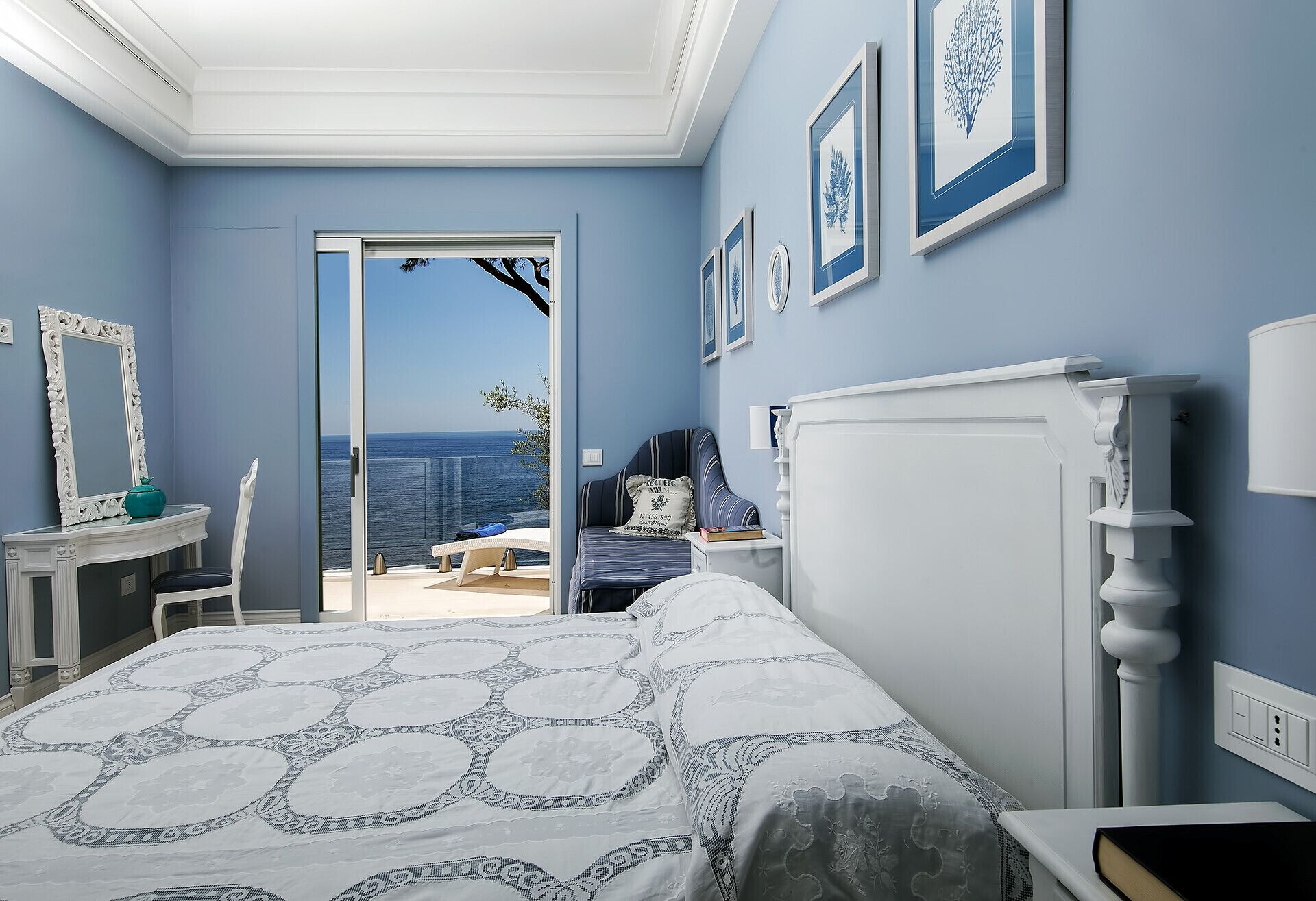 Une chambre avec un grand lit, une vue sur la mer et un balcon.