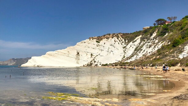 Ein Strand mit weißen Klippen und klarem Wasser.