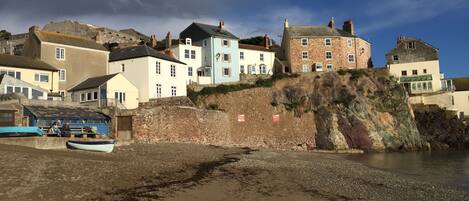 A coastal town with buildings on a cliff overlooking the sea.