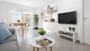 Un salon moderne avec un canapé, une table à manger et un téléviseur.