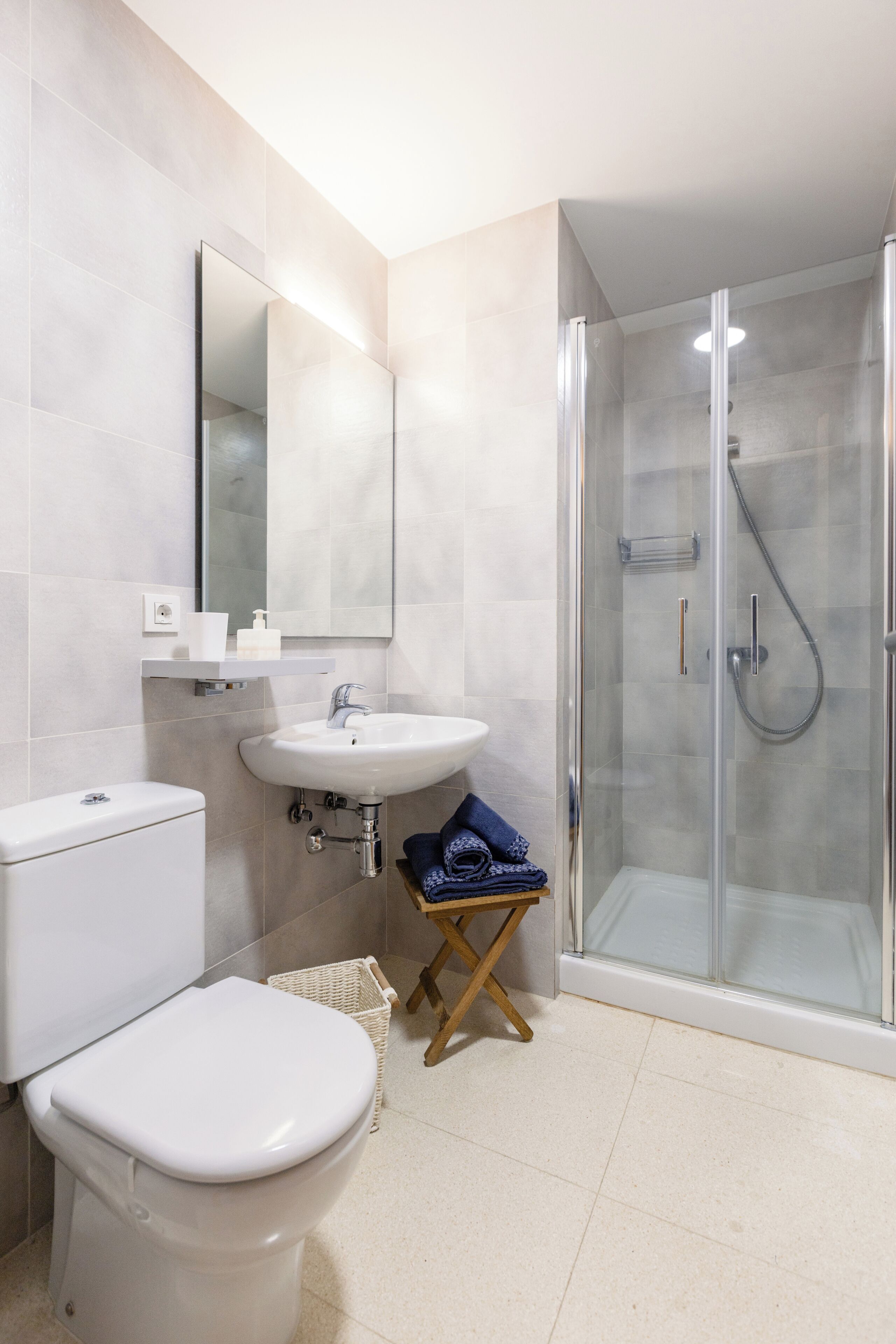 A modern bathroom with a toilet, sink, and glass-enclosed shower.