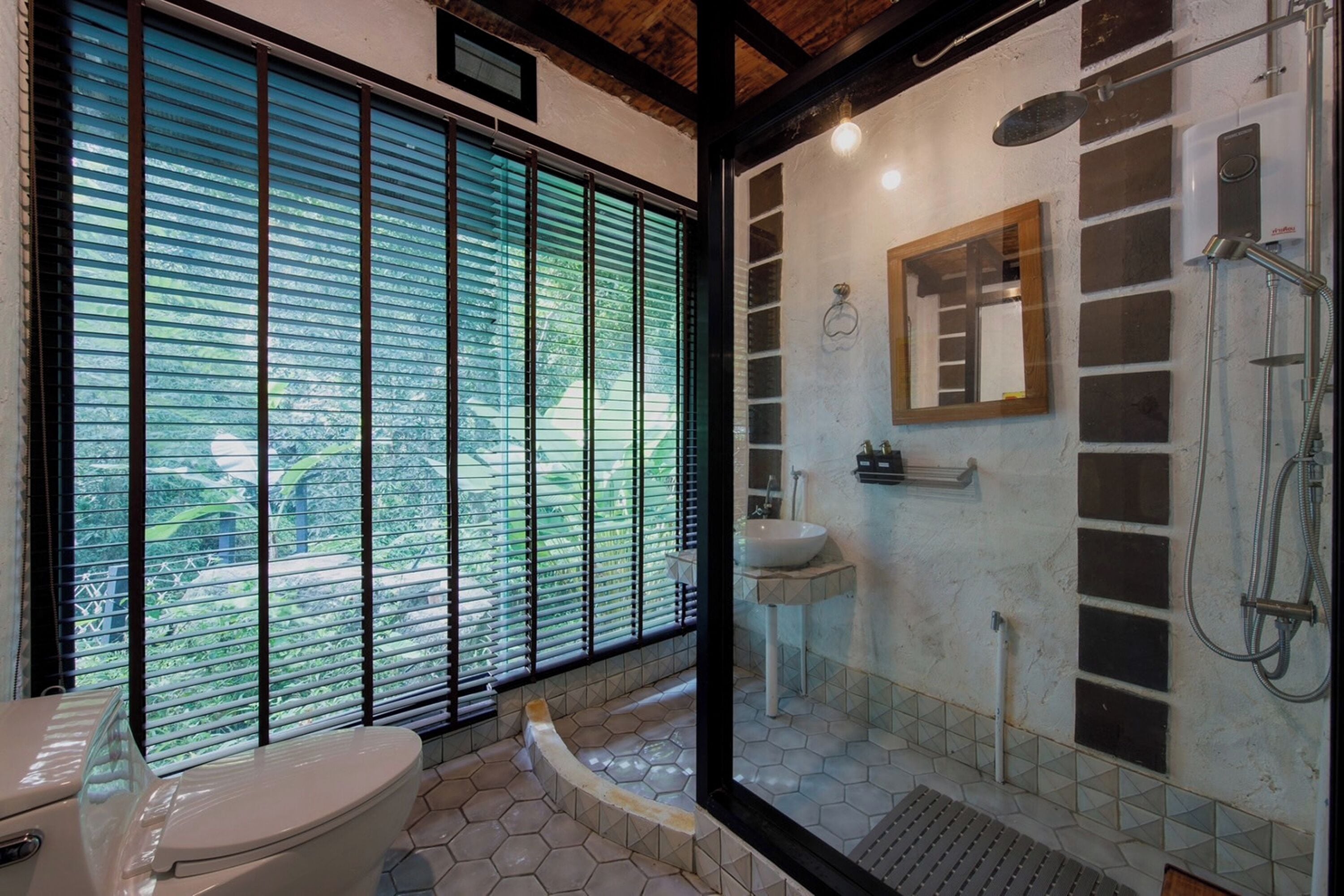A bathroom with a toilet, sink, and shower.