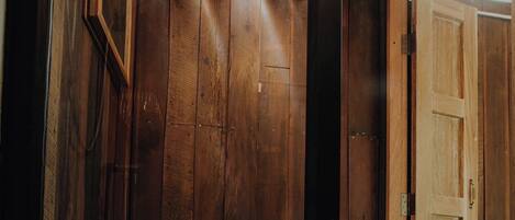 Een houten badkamer met een toilet en een douche.