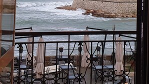 A seaside view from a balcony with outdoor seating and a rocky shoreline. - Mowita seaside flat with stunning view on the sea (Civitavecchia)