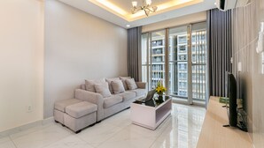 A modern living room with a sofa, a coffee table, and a TV. - Scenic Valley - Vina We Stay Apartment (Ho Chi Minh City)