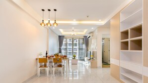 A modern kitchen with a dining table, chairs, and pendant lighting. - Scenic Valley - Vina We Stay Apartment (Ho Chi Minh City)