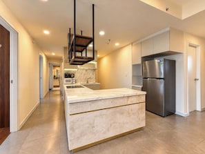 A modern kitchen with a central island, stainless steel appliances, and a marble backsplash. - Scenic Valley - Vina We Stay Apartment (Ho Chi Minh City)