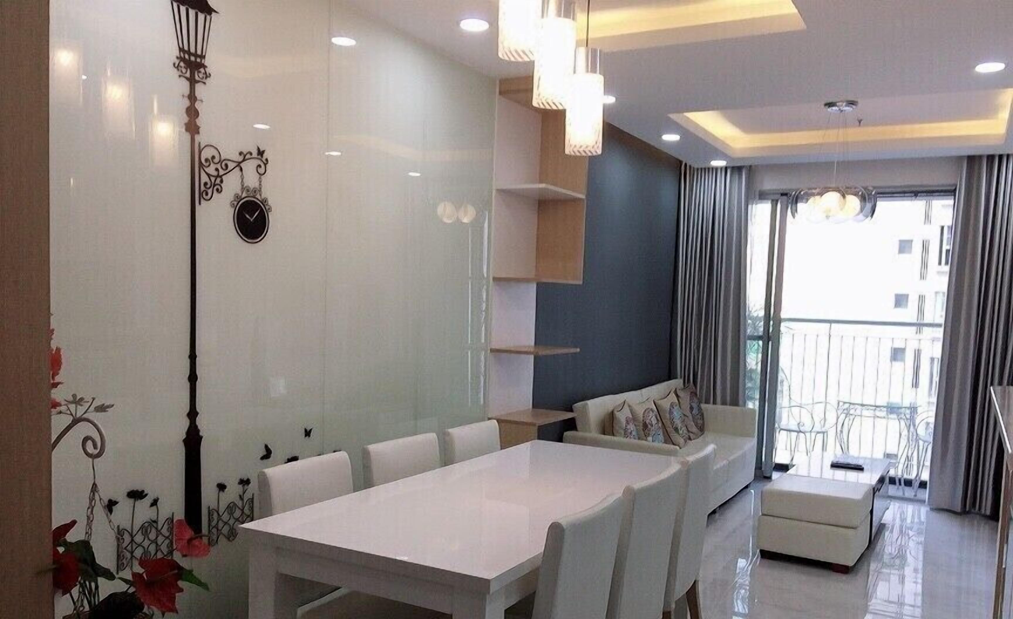 Un salon moderne comprenant une table à manger, un canapé et des éléments décoratifs muraux.