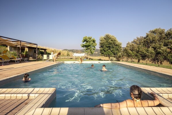 Una piscina al aire libre, una piscina climatizada