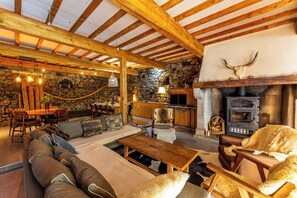 A cozy lodge with a stone fireplace, wooden beams, and rustic furnishings. - Mansion - Aste Béon (Aste Béon)