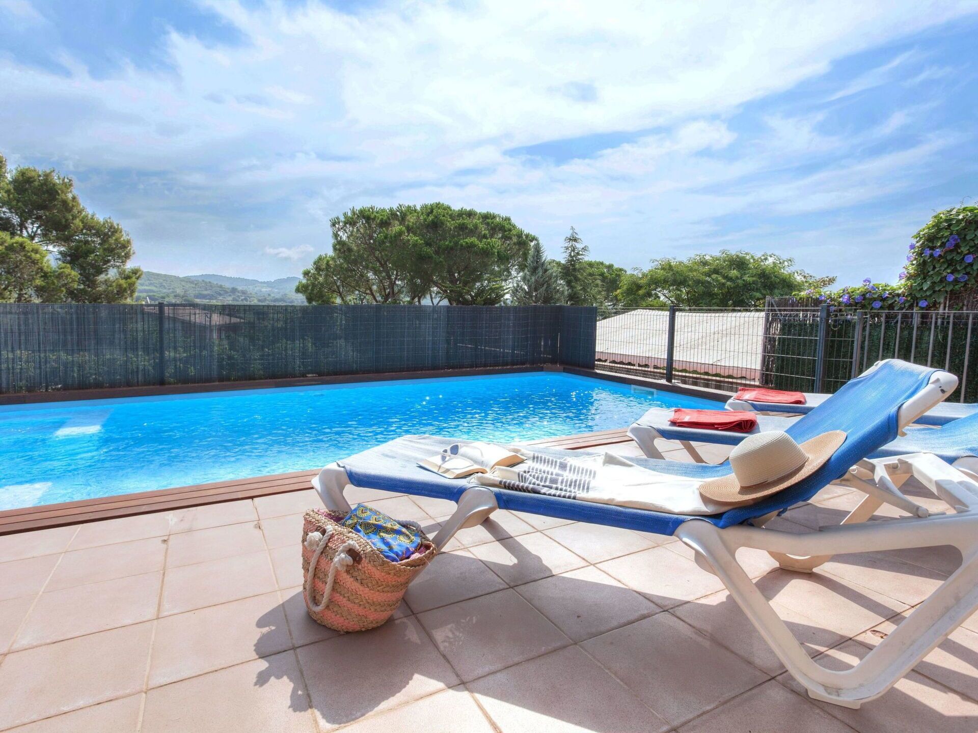 Ein Swimmingpool mit Liegestühlen und einem Korb voller Gegenstände.