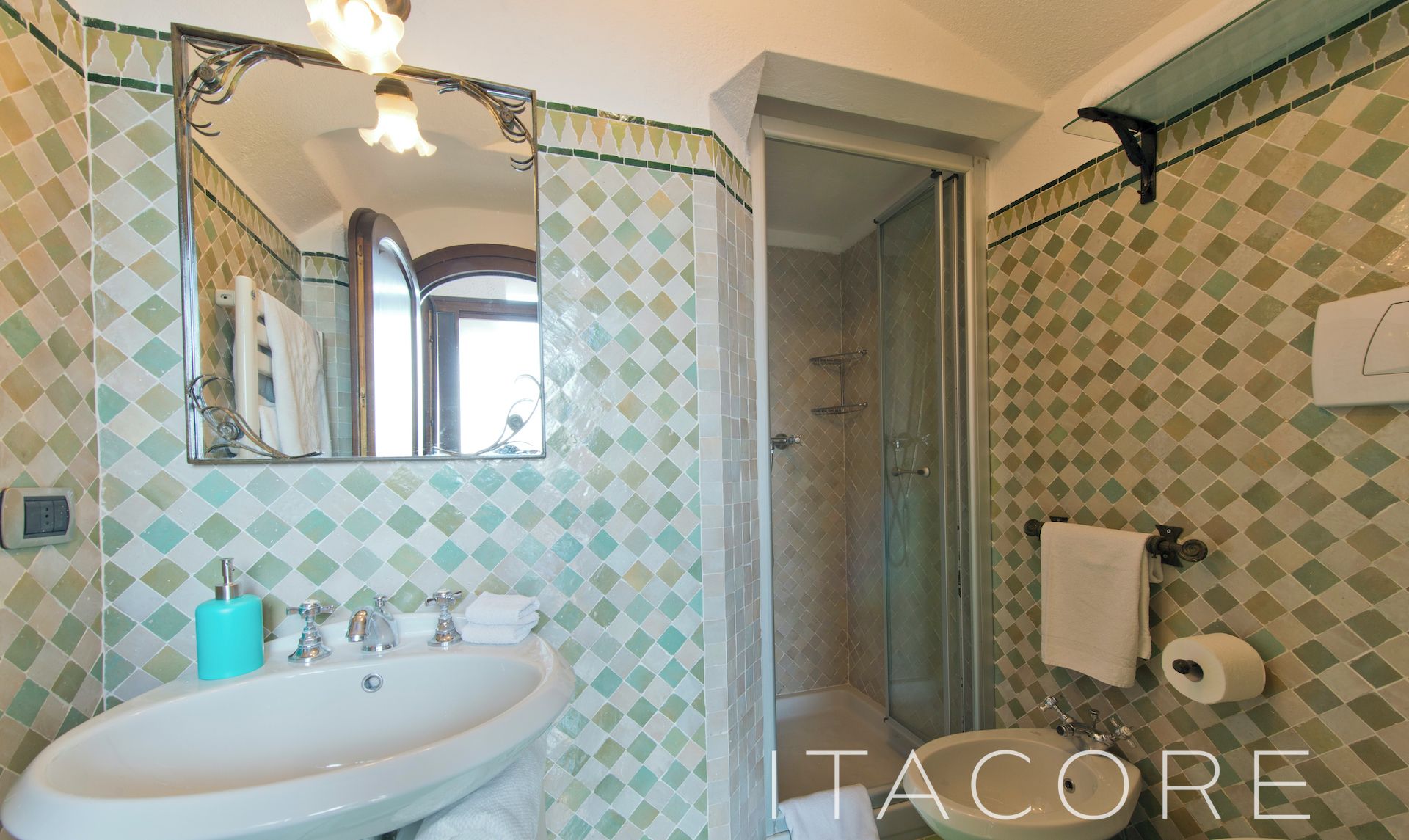 Une salle de bain avec un lavabo, un miroir et un espace douche.