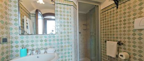 Une salle de bain avec un lavabo, un miroir et un espace douche.